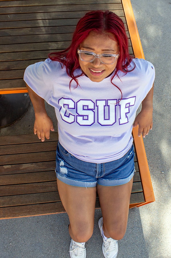 Student wearing a purple CSUF block t-shirt