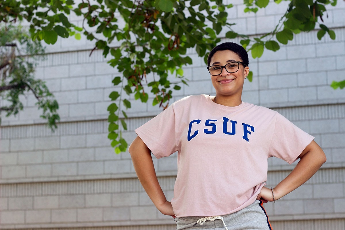 Student wearing a pink tee with navy blue letters